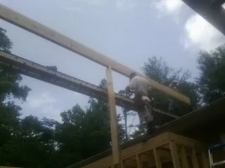 Carpenter setting a ridge beam over a new addition frame — Ice Dam Removal by Roofing Brothers in Closter