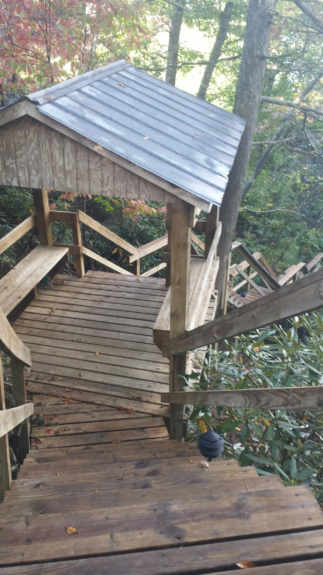 Metal roofed shelter over wooden steps on a wooded walkway — Skylight Repair & Installation work by our crew in Closter
